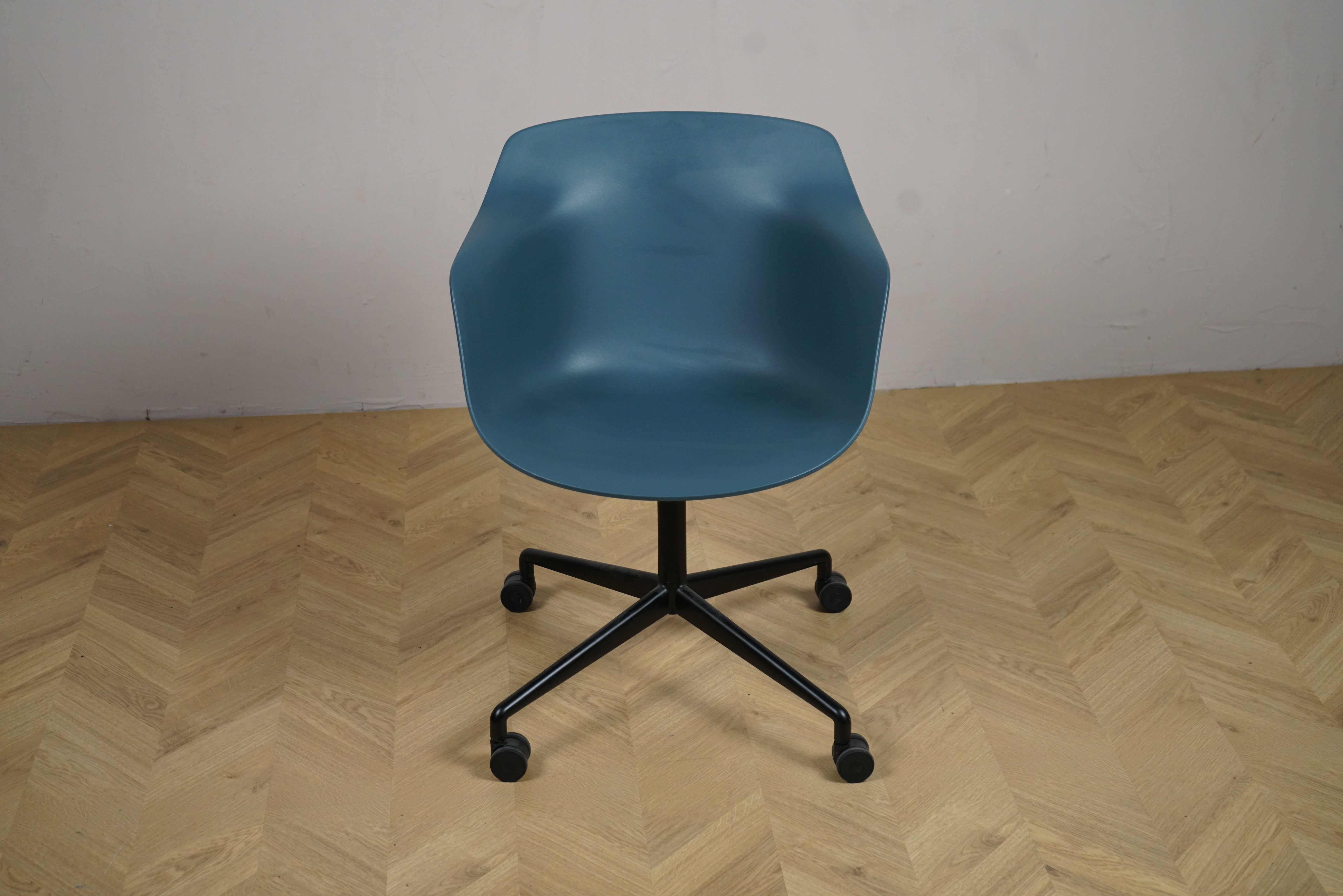 Kinnarps blå skaldstol med sorte ben og hjul set forfra